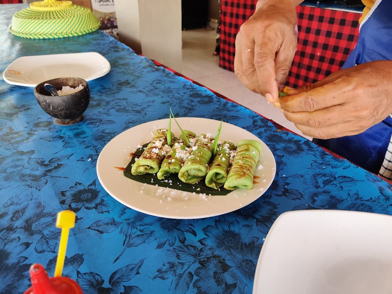 Green coconut crepes arranged on a blue outdoor table